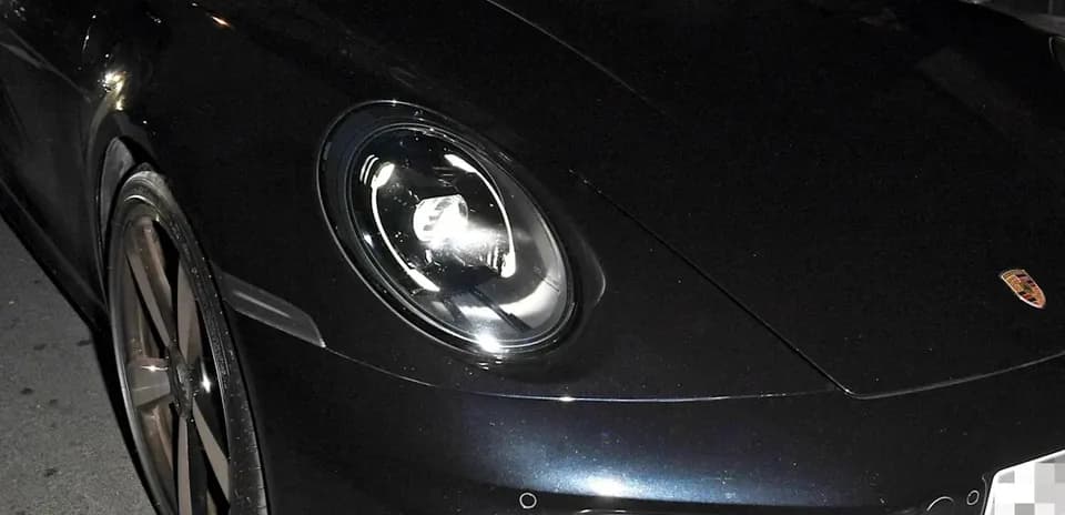 Deux hommes dans une voiture de sport noire