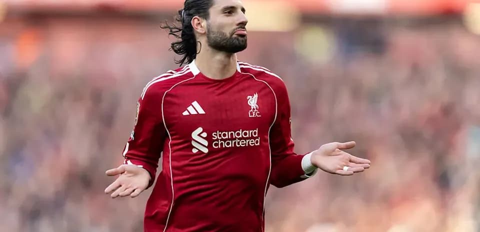 Joueur de Liverpool avec les bras écartés sur le terrain
