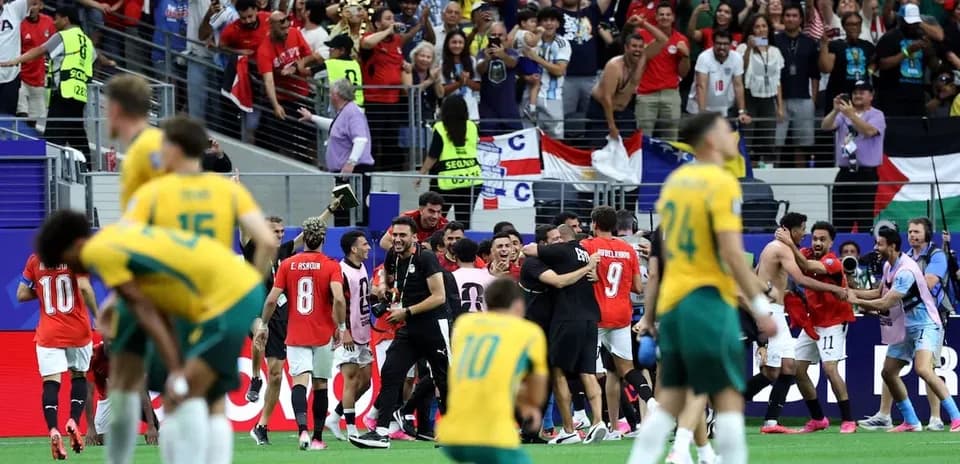 Joueurs célébrant une victoire avec des supporters en arrière-plan
