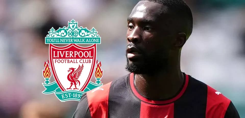 Joueur en maillot noir et rouge près du logo Liverpool