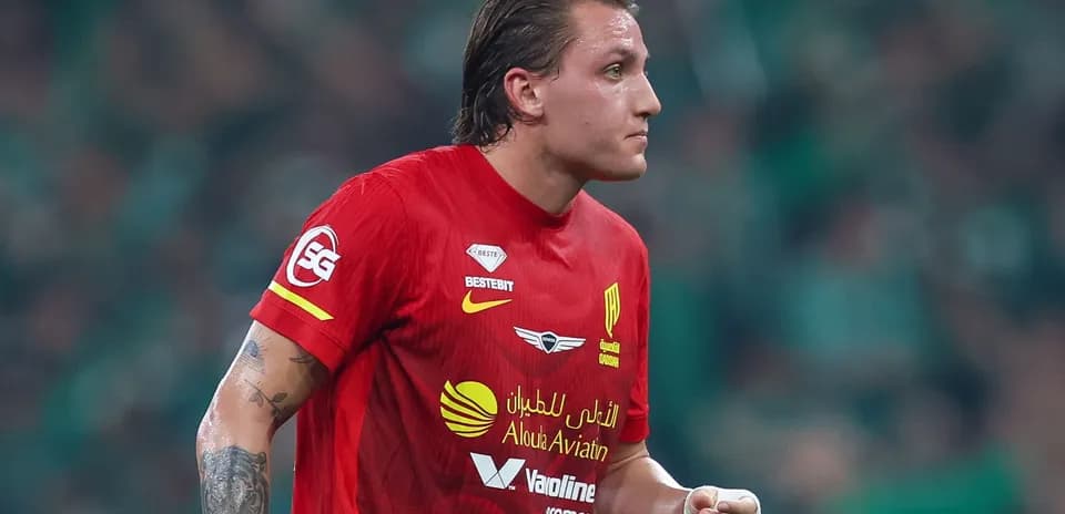 Joueur en maillot rouge sur le terrain de football