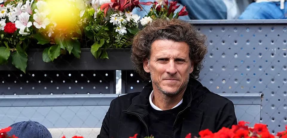 Homme regardant un match de tennis entouré de fleurs