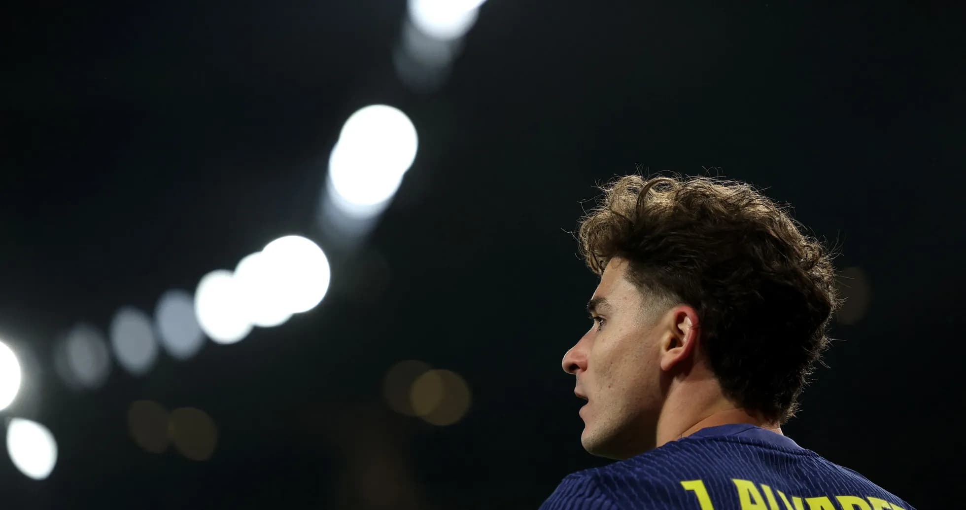 Joueur regardant le terrain sous les lumières du stade