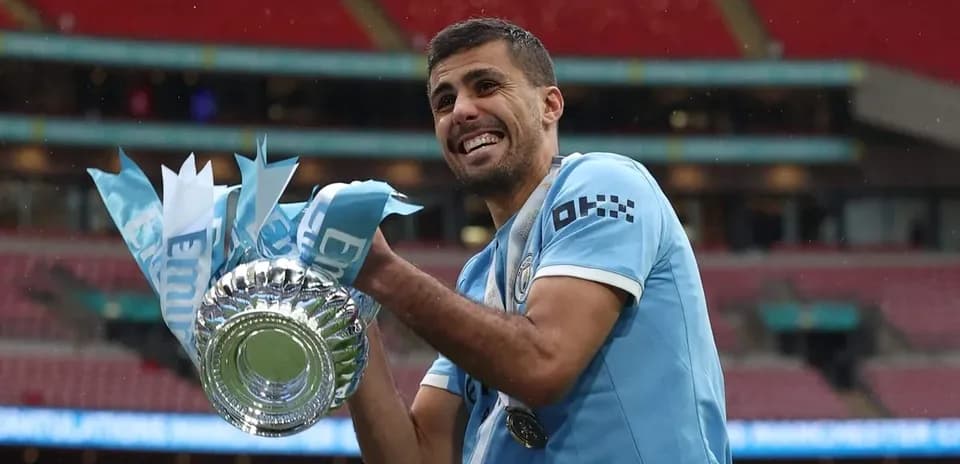 Joueur de Manchester City tenant un trophée