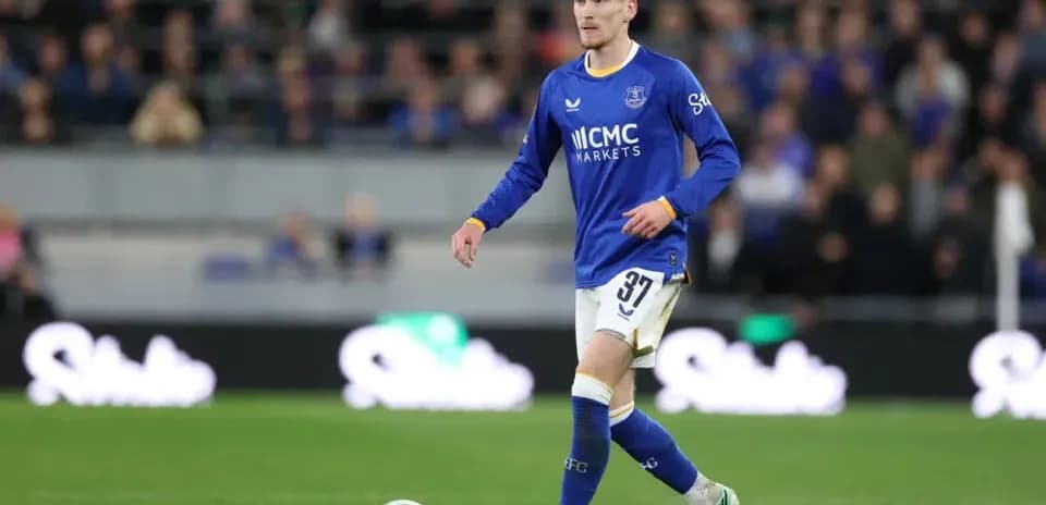 Joueur en maillot bleu marchant sur le terrain
