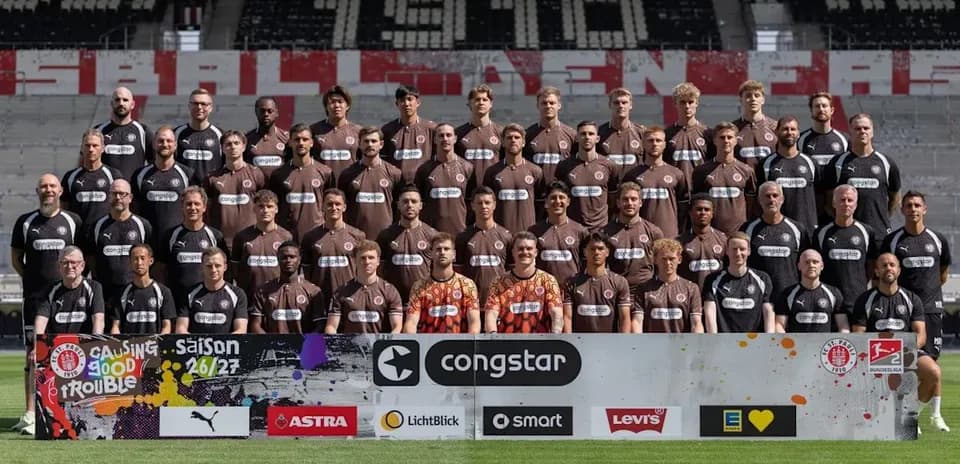 Équipe de football posant avec maillots à l'extérieur
