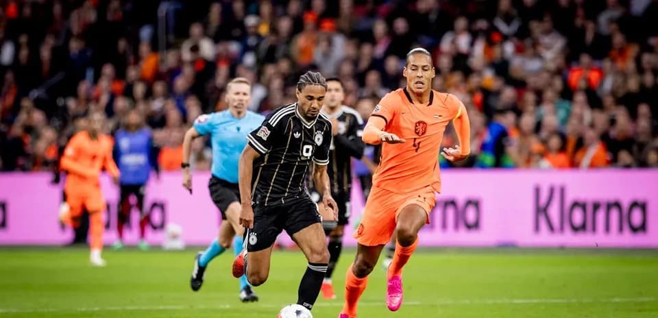 Joueur en noir dribblant avec défenseur en orange