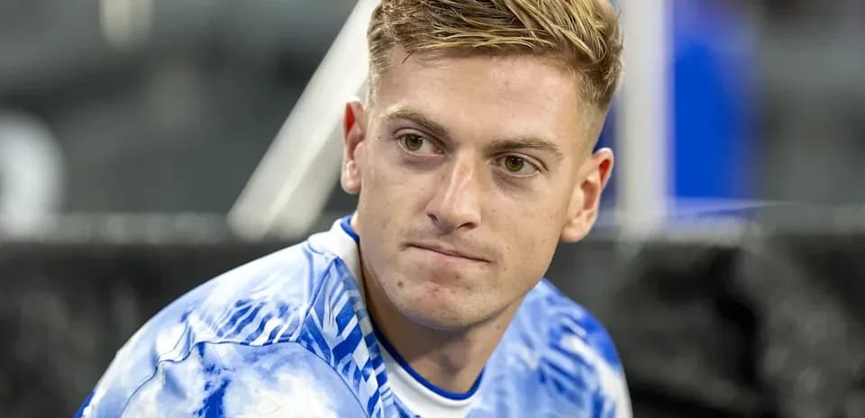 Joueur assis en maillot bleu à motifs nuageux