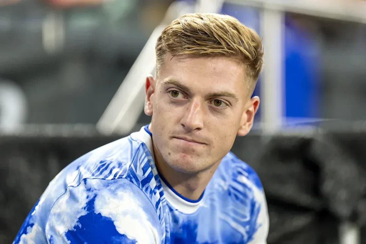 Joueur assis en maillot bleu à motifs nuageux