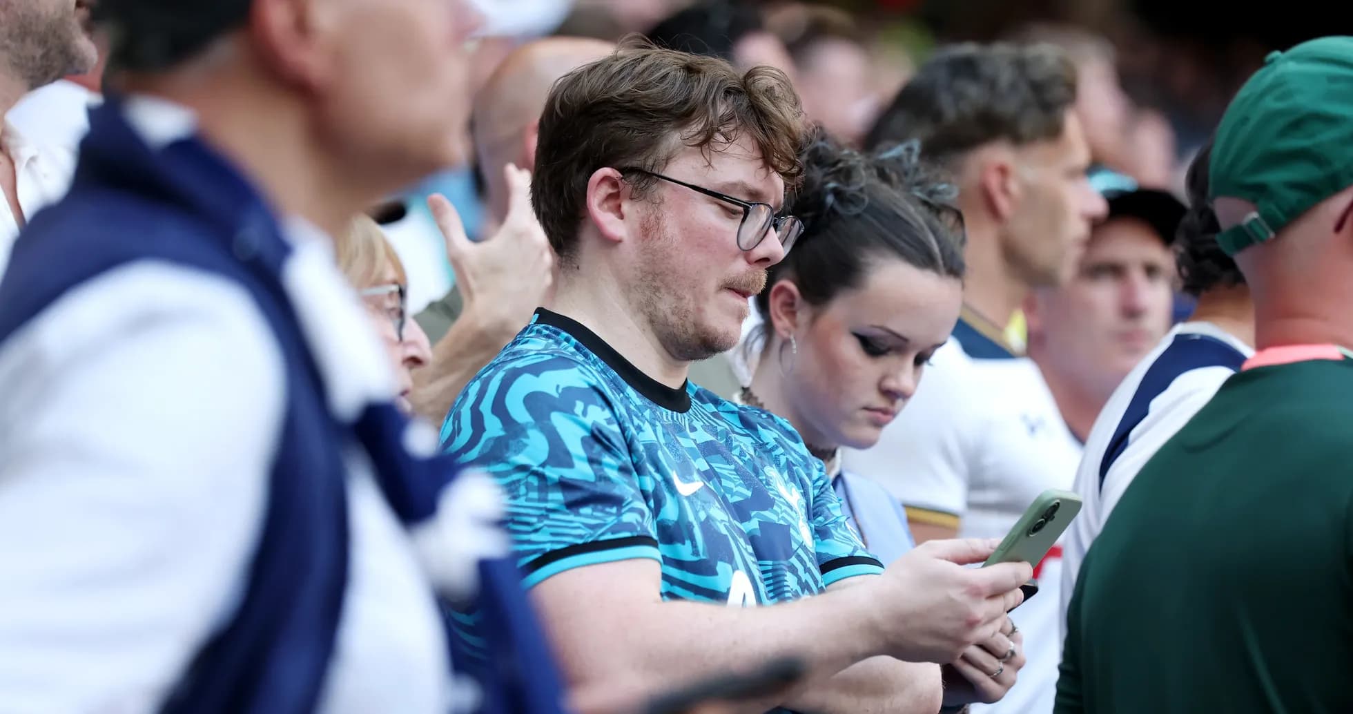 Spectators looking at their phones during event