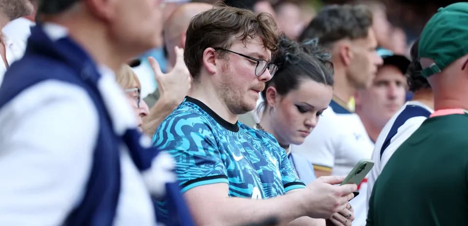 Spectators looking at their phones during event