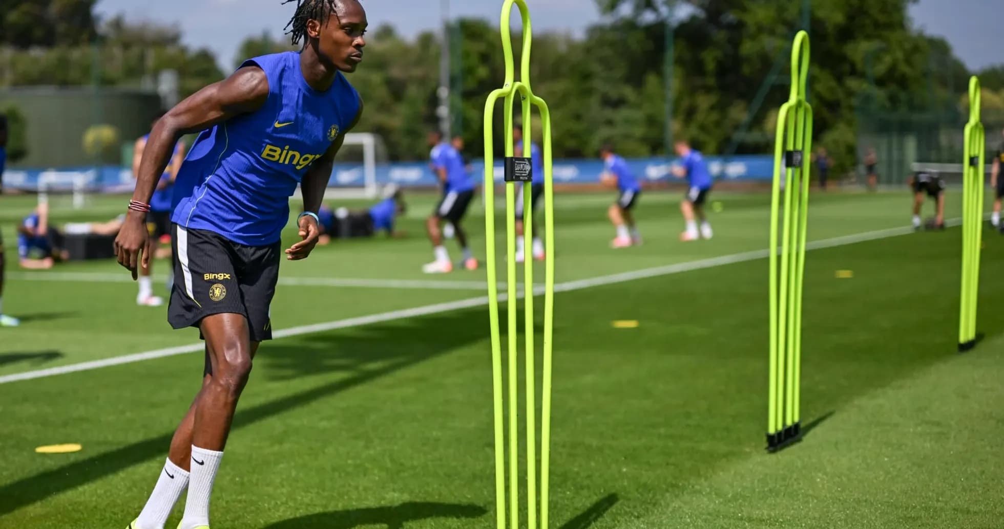 Joueur courant entre des plots d'entraînement sur le terrain