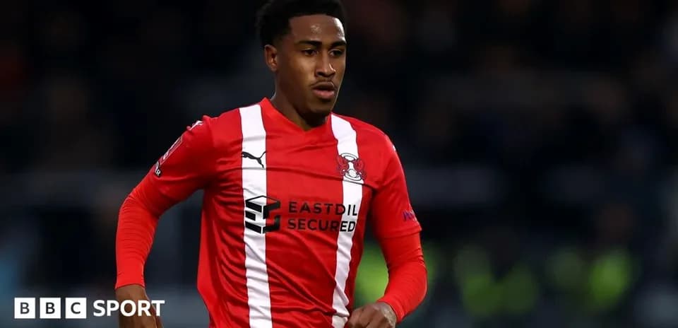 Joueur de football en maillot rouge courant sur le terrain