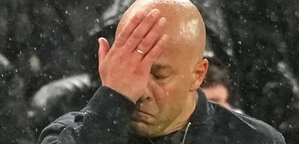 Entraîneur se tenant le front sous la pluie