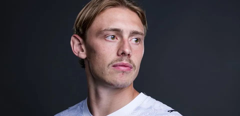 Joueur de football en maillot blanc, regardant à droite