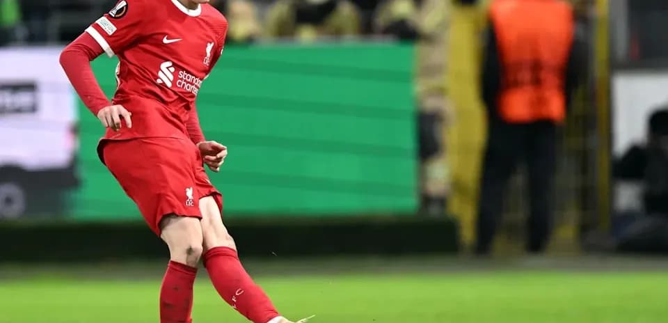 Joueur de Liverpool frappant le ballon sur le terrain