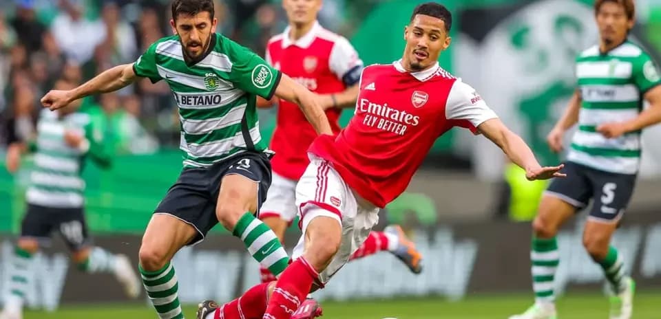 Un joueur d'Arsenal affrontant un joueur du Sporting CP
