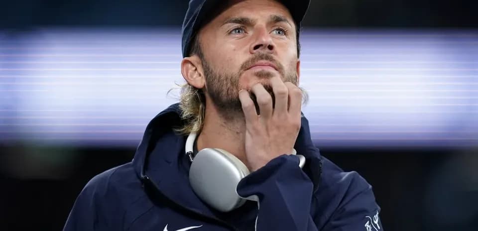 Homme pensif portant des écouteurs, en tenue sportive