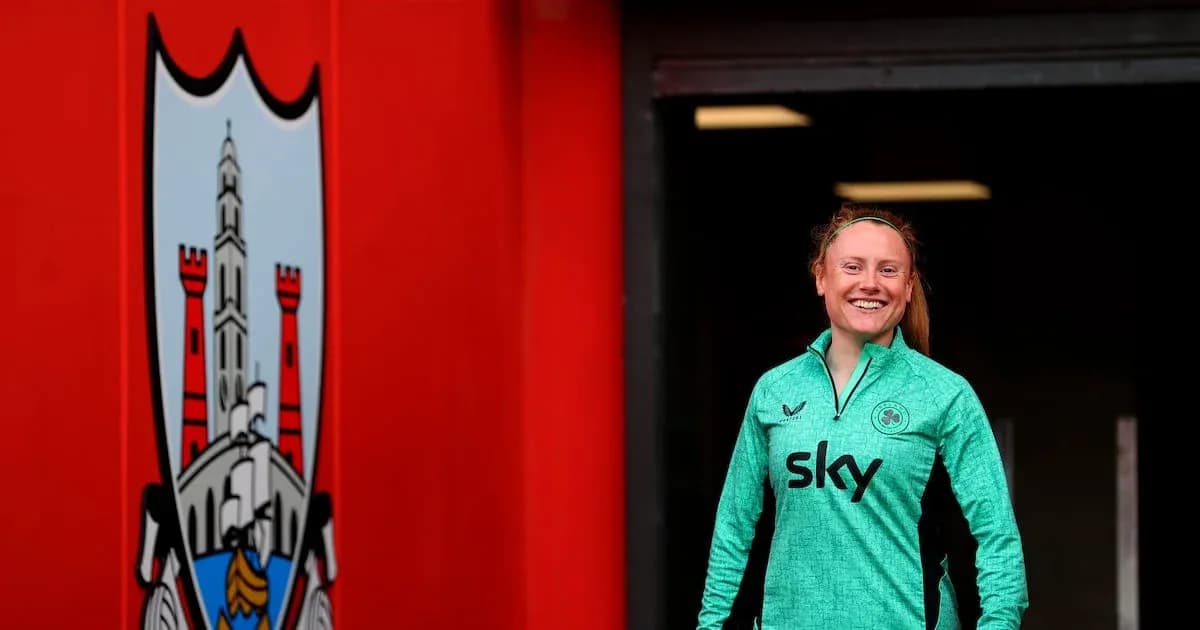 Joueuse souriante portant un maillot vert à l'entrée du stade
