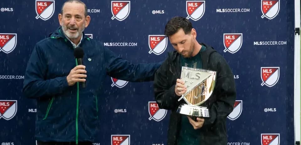 Lionel Messi holding MLS trophy during press event