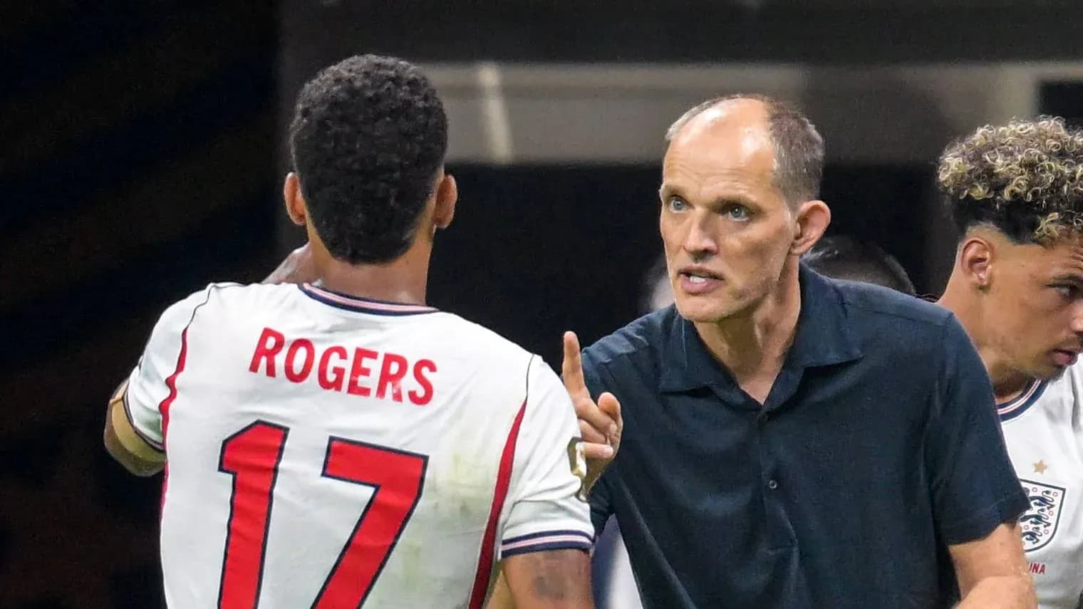 Entraîneur discutant avec le joueur Rogers sur le terrain