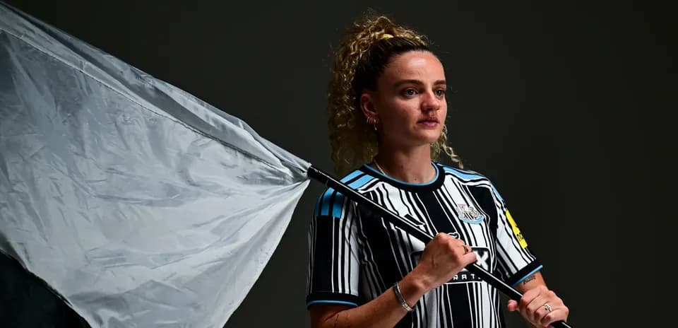 Joueuse tenant un drapeau, portant un maillot de Newcastle