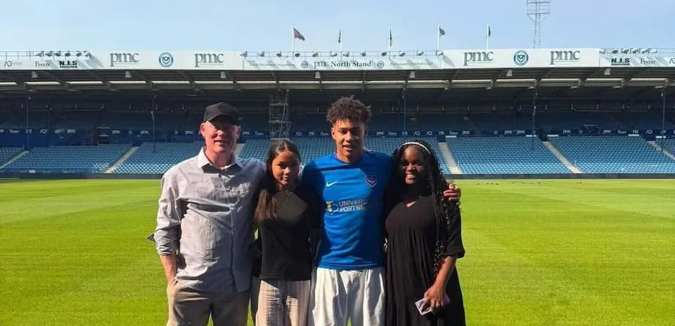 Quatre personnes posant sur le terrain de football