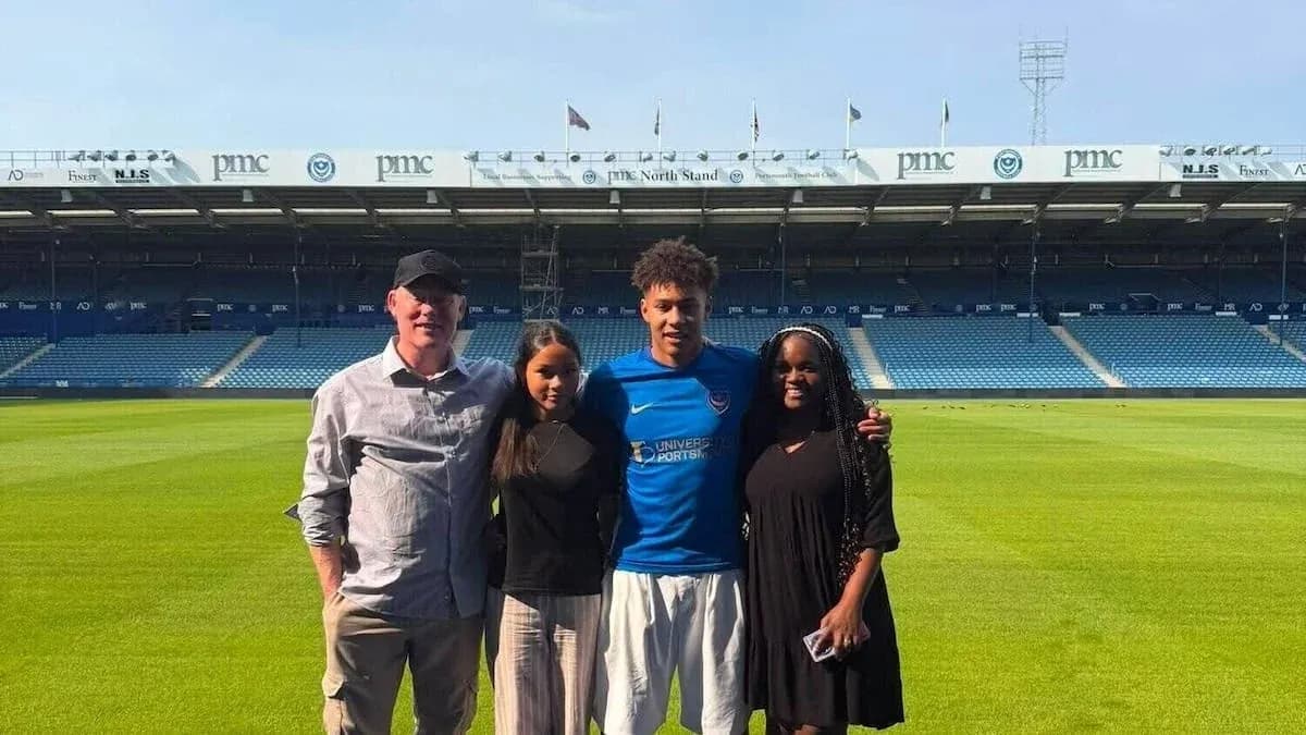 Quatre personnes posant sur le terrain de football