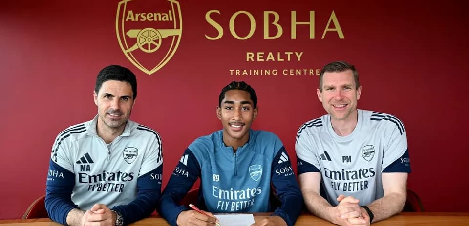 Joueur signant contrat avec entraîneurs à Arsenal