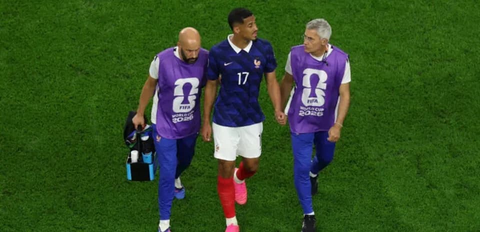 Joueur de France accompagné par entraîneurs sur le terrain