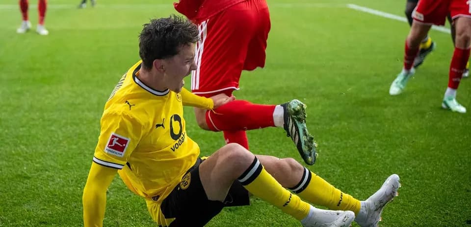 Joueur de Dortmund tombé au sol après un tacle