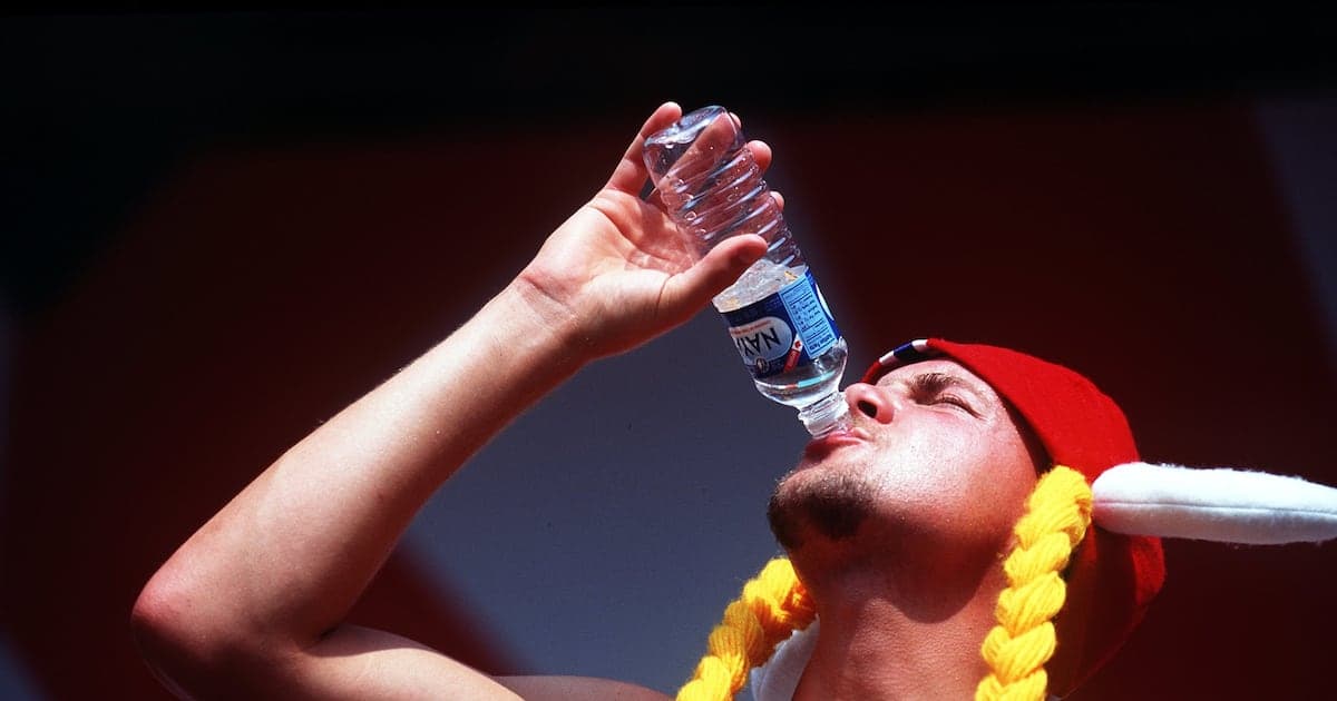 Homme buvant de l'eau en portant un chapeau