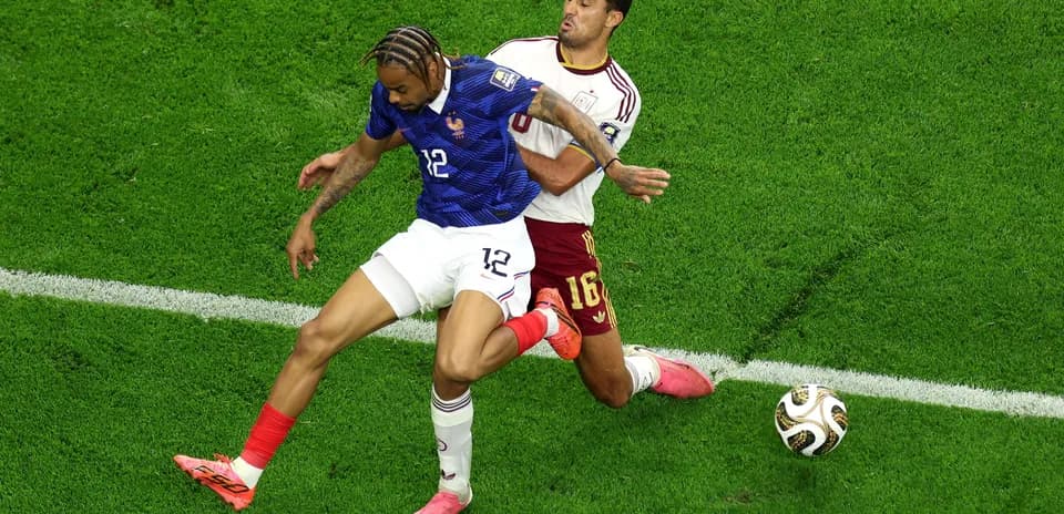 Joueur français dribblant un adversaire pendant un match