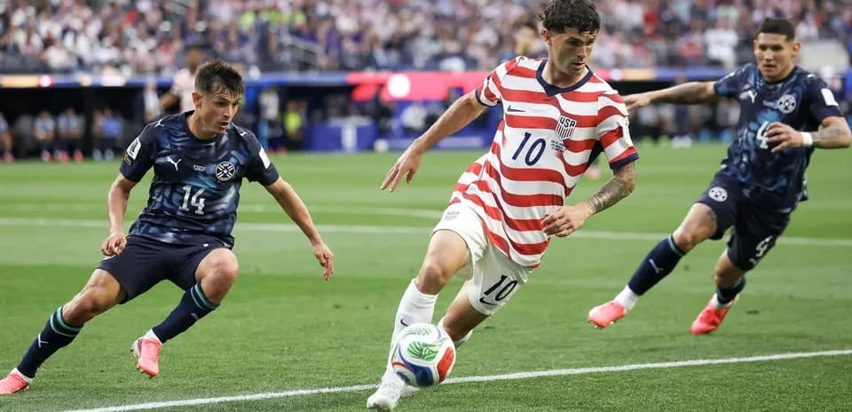 Christian Pulisic dribbling past defenders during match