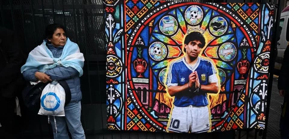 Femme avec écharpe argentine devant une fresque de Maradona