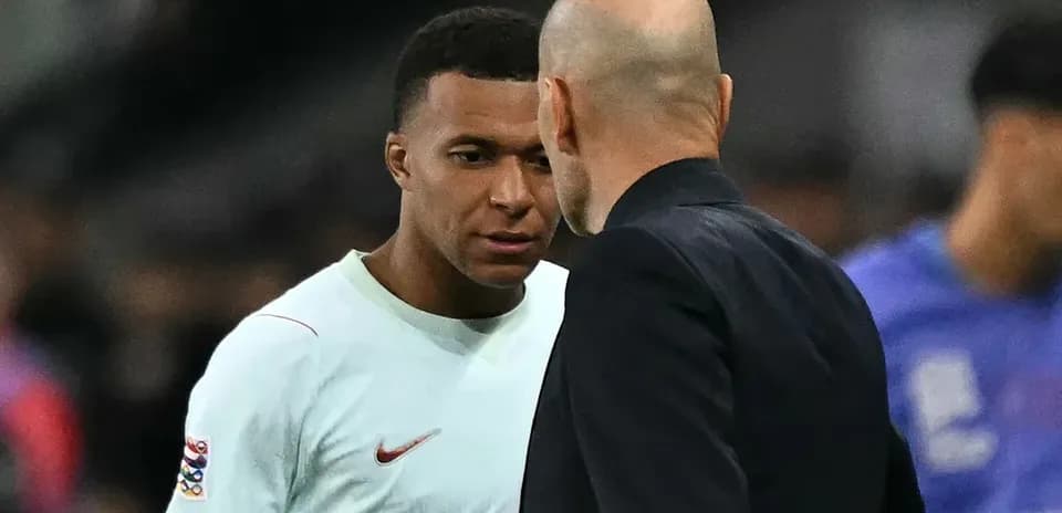 Kylian Mbappé et entraîneur discutant sur le terrain