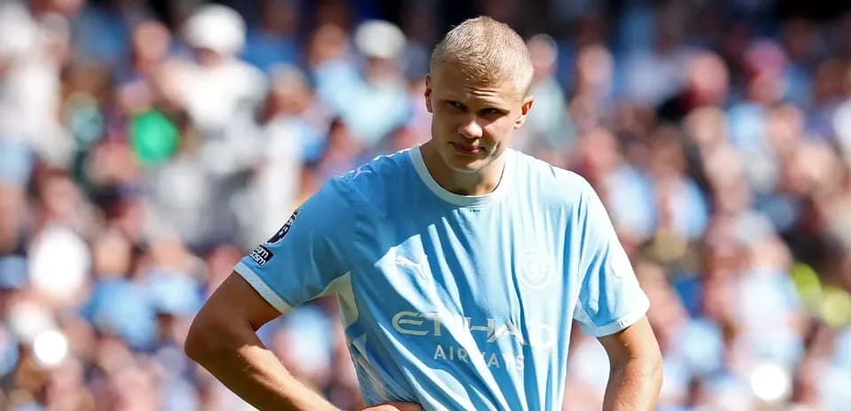 Joueur de Manchester City sur le terrain, regard pensif