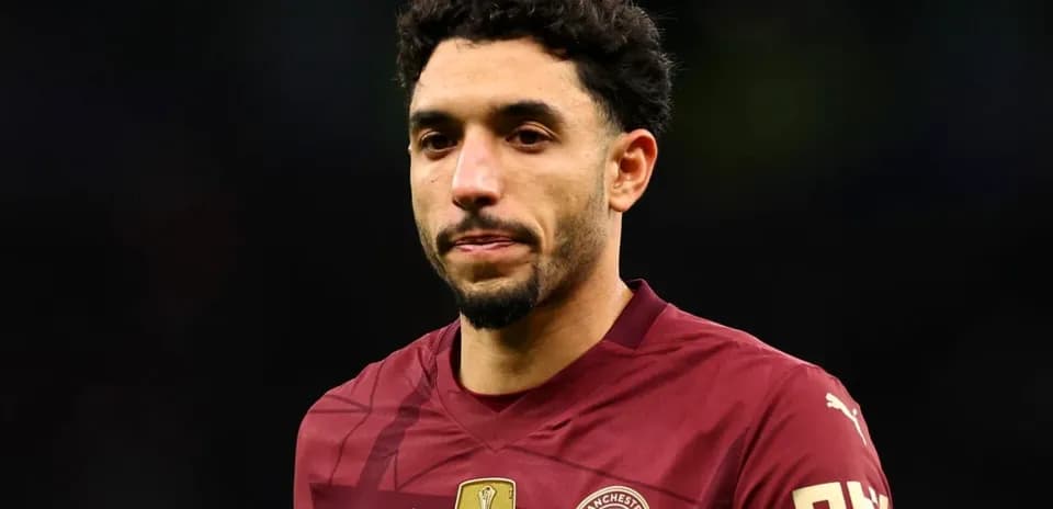 Joueur de Manchester City en maillot rouge sur le terrain