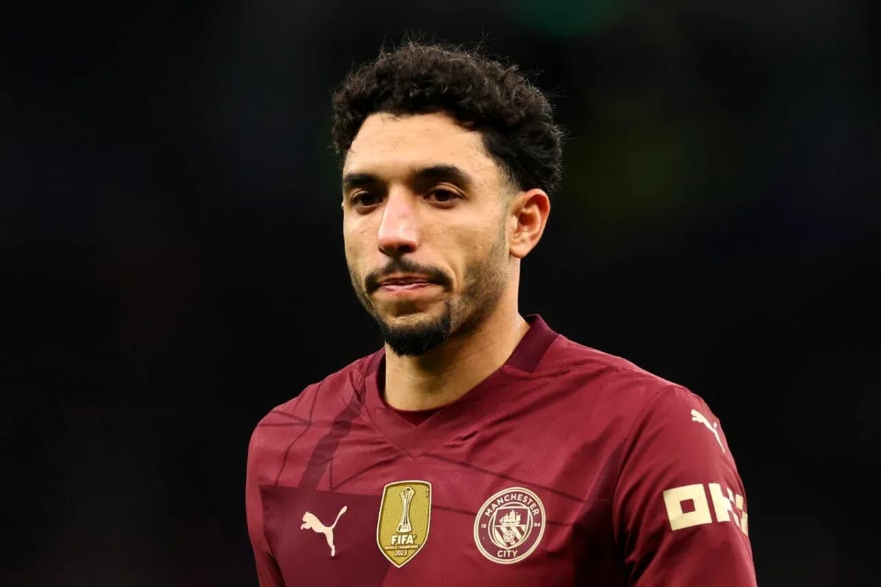 Joueur de Manchester City en maillot rouge sur le terrain