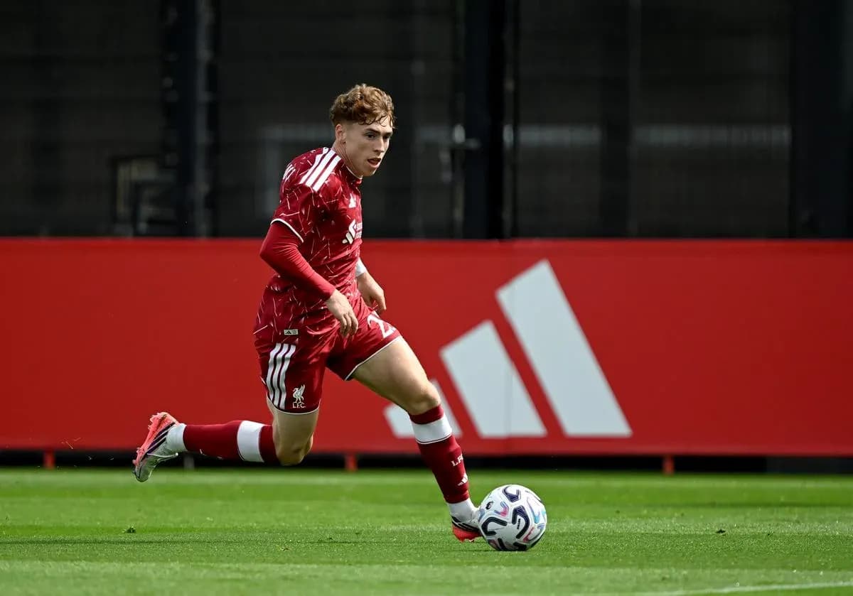 Joueur en maillot rouge dribblant avec le ballon Joueur en maillot rouge dribblant avec le ballon