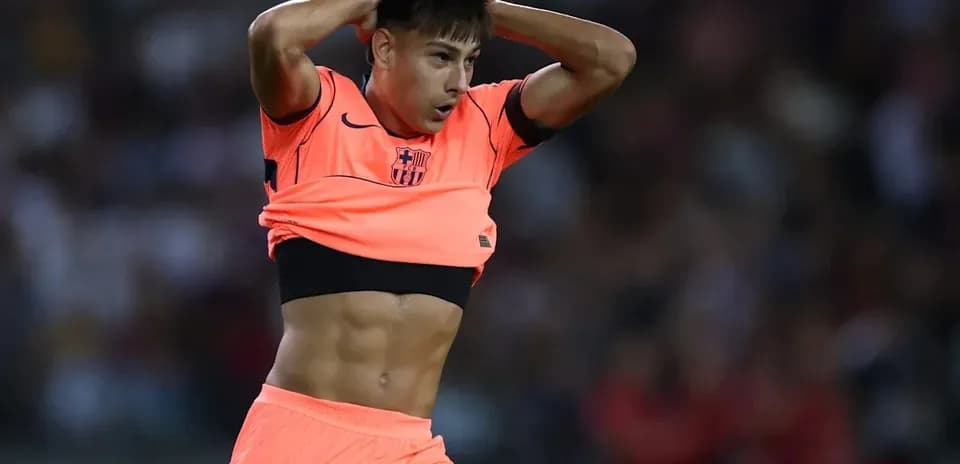 Joueur en maillot rose retirant son haut sur le terrain