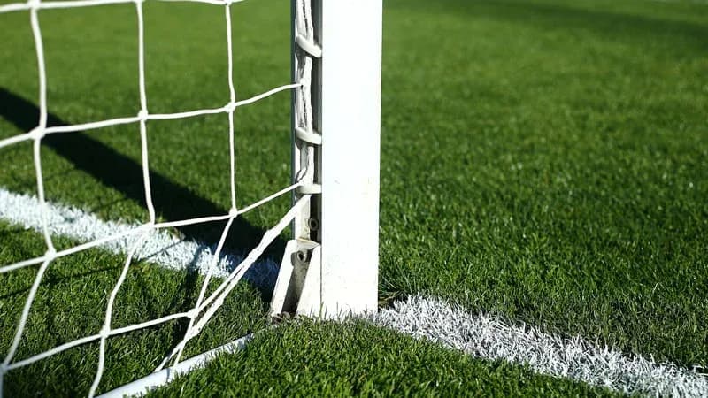 Coin d'un but de football sur terrain en gazon