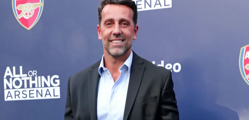 Person souriant devant un panneau Arsenal