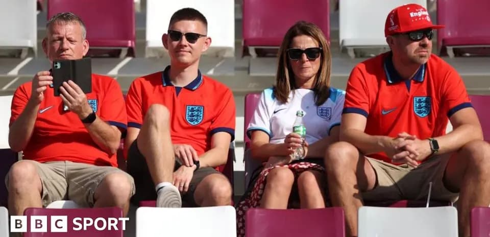 Supporters wearing England jerseys in stadium seats