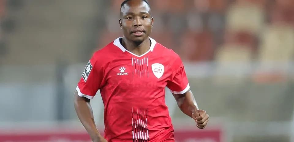 Joueur en maillot rouge courant sur le terrain