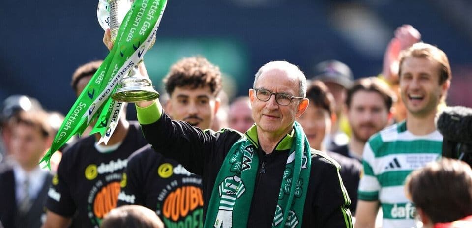 Entraîneur levant le trophée avec des joueurs en arrière-plan