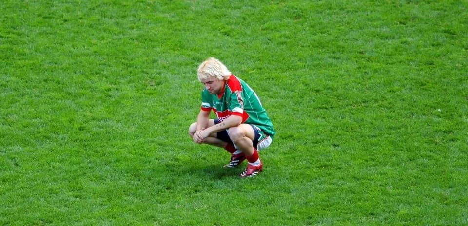 Joueur accroupi sur le terrain de football