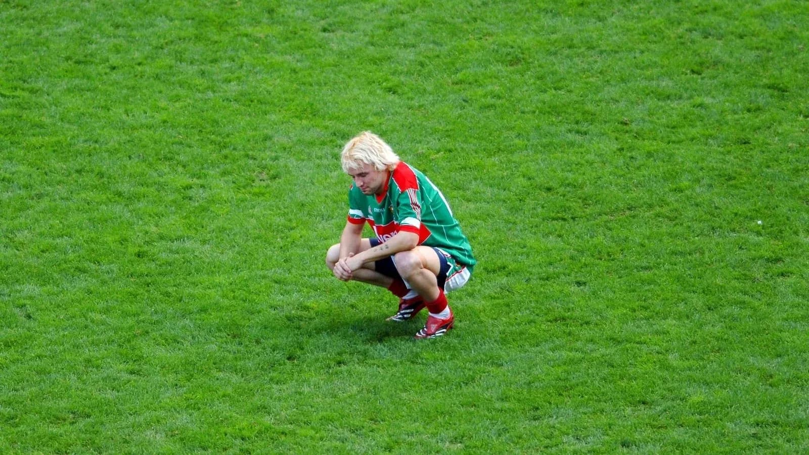Joueur accroupi sur le terrain de football