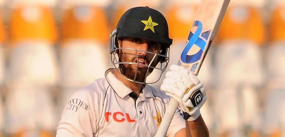 Joueur de cricket levant sa batte sur le terrain