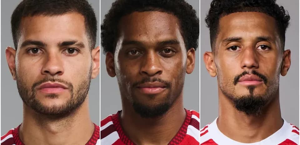 Trois joueurs posant en maillot rouge sur fond gris